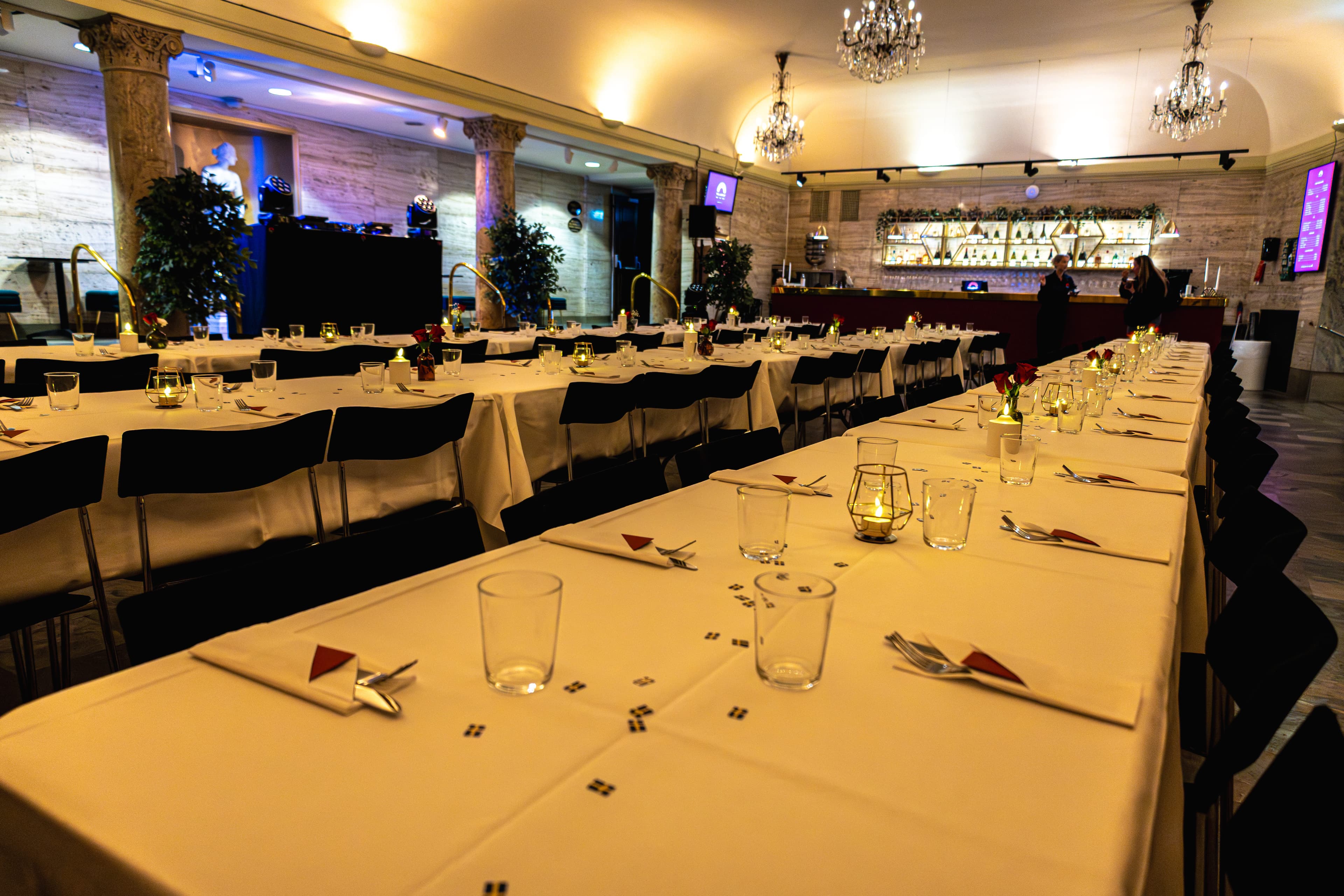 Banquet tables set for dinner beside The Marble Foyer's bar