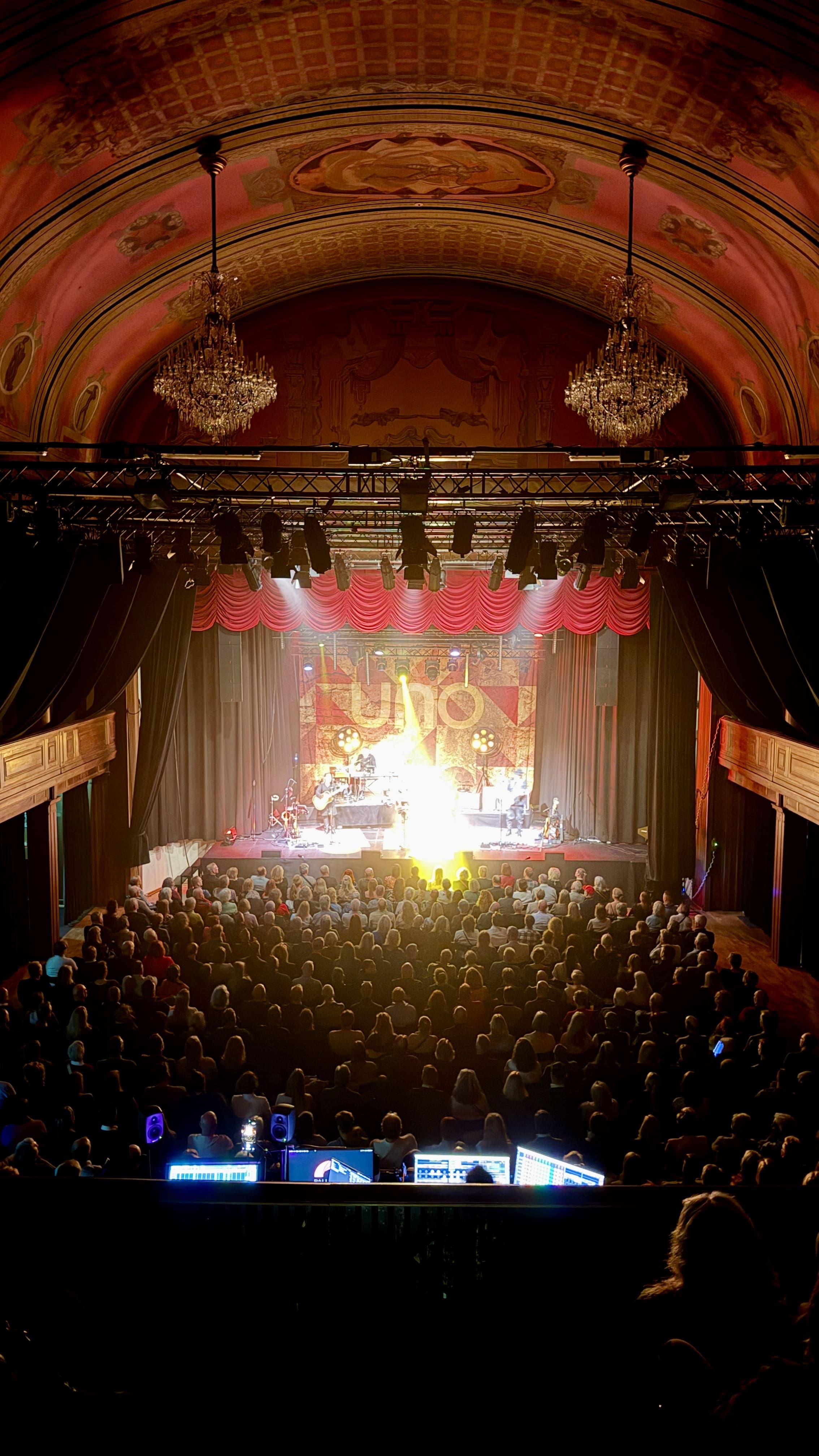 View from the balcony with crystal chandeliers and ceiling murals during a concert