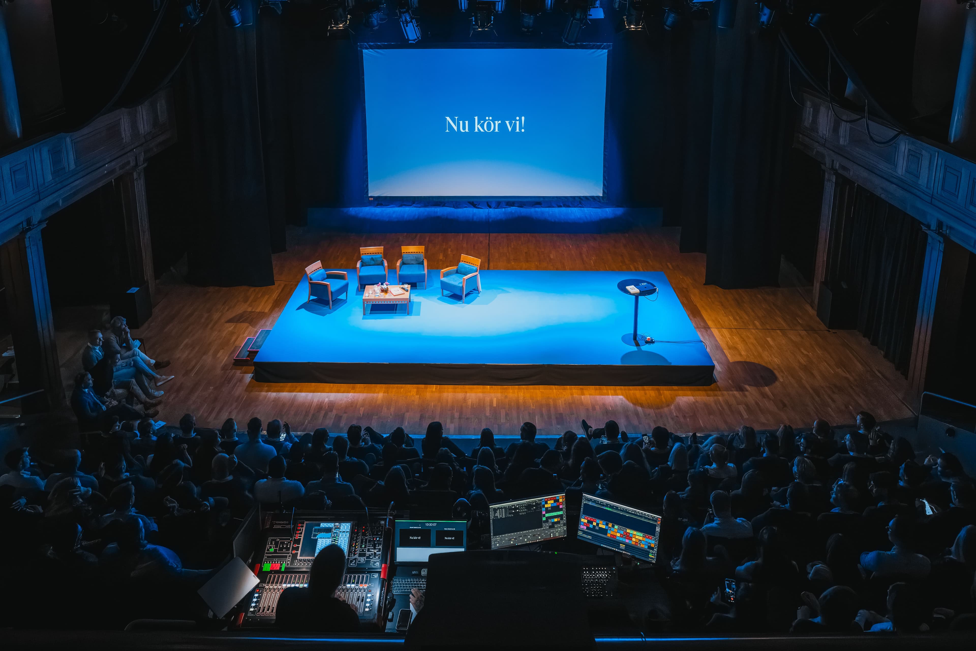 Conference in The Main Hall with stage, armchairs and projection screen